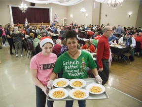 Chloe Cripps, left, and Fatima Harris were just two of the many volunteers who helped to serve the Marconi Club’s annual Christmas meal for the needy in London on Sunday. (DEREK RUTTAN, The London Free Press)