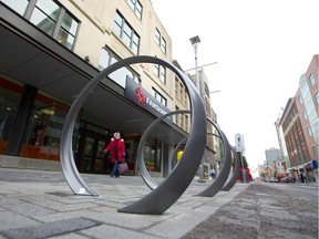 Tina Hibbard, of London, walks along Dundas Street in London's first section of the flex street between Richmond and Talbot. The flex street features modern loops meant to be used as bike racks. (MIKE HENSEN, The London Free Press)