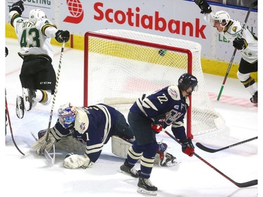 Knights' Paul Cotter leaps over Windsor's Karl Piiroinen after scoring the Knights first goal on a pass from Antonio Stranges to tie up their game at Budweiser Gardens on Friday December 28, 2018.  Windsor opened the scoring but the Knights came back on goals by Paul Cotter and Nathan Dunkley to lead 2-1 at the first intermission. Mike Hensen/The London Free Press/Postmedia Network