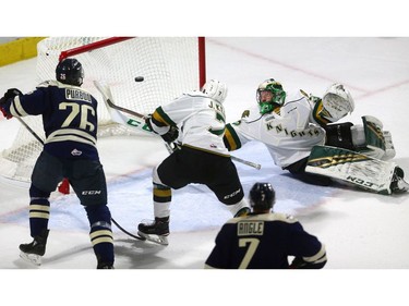 Knights' goalie Joseph Raaymakers reaches back to knock the puck out of the air to save a goal as defenseman Joey Keane tries to get to the puck before Windsor's Cole Purboo in the first period of their game at Budweiser Gardens on Friday December 28, 2018.  Windsor opened the scoring but the Knights came back on goals by Paul Cotter and Nathan Dunkley to lead 2-1 at the first intermission. Mike Hensen/The London Free Press/Postmedia Network
