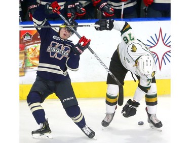 Windsor's Tyler Angle loses his lid as he tangles with Billy Moskal of the Knights early in their game at Budweiser Gardens on Friday December 28, 2018.  Windsor opened the scoring but the Knights came back on goals by Paul Cotter and Nathan Dunkley to lead 2-1 at the first intermission. Mike Hensen/The London Free Press/Postmedia Network