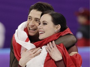Tessa Virtue and Scott Moir of Canada celebrate during the venue ceremony after winning the gold medal in the ice dance, free dance figure skating final at the 2018 Winter Olympics in Gangneung, South Korea, on Feb. 20, 2018. (David J. Phillip/AP)