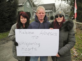 Natalie Tupper, right, of Waterford, has been upset in recent months as three horses at a hobby farm in Townsend Centre have become progressively malnourished. She and dozens of others gathered outside the property Saturday to protest the situation and demand that the authorities act. With Tupper is her parents Karen and Terry Tupper of Mount Hope.