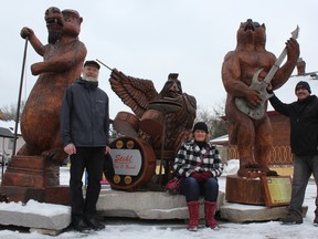 Neil Cox, Laura Wenzoski and Robbin Wenzoski (left to right) show off the three newest sculptures carved for the Hamilton Road tree trunk tour. The animal bandmates pay tribute to London's music history. (MEGAN STACEY/The London Free Press)