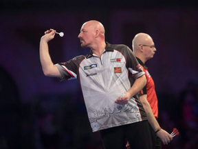 Jim Long of London, Ont., throws a dart during his first-round match on Dec.15, 2018 in London, England (CP)