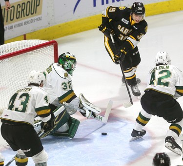 Sarnia's Jamieson Rees comes out from behind the London net and gets a pass to Ryan McGregor across the crease in front of Knights' goaltender Joseph Raaymakers as Jacob Golden closes in during the first period of their game at Budweiser Gardens on Sunday December 2, 2018. 
Mike Hensen/The London Free Press/Postmedia Network
