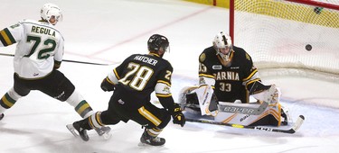 Alec Regula of the Knights is stopped by Sting goaltender Ethan Langevin as he's checked by Kelton Hatcher during the first period of their game at Budweiser Gardens on Sunday December 2, 2018. 
Mike Hensen/The London Free Press/Postmedia Network