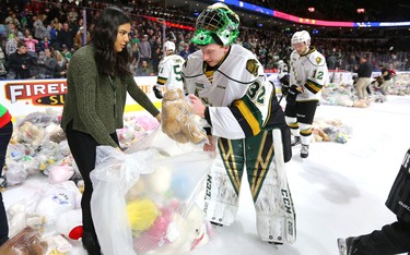 Joseph Raaymakers helps out as staff and volunteers start to collect teddy bears after Knights' defenceman Adam Boqvist scored late in the first period of their game unleashing the teddy bear toss during their game against the Sarnia Sting at Budweiser Gardens on Sunday December 2, 2018. 
Mike Hensen/The London Free Press/Postmedia Network