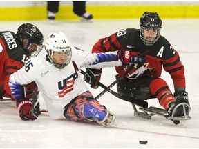 Team USA's Declan Farmer and Team Canada's Antoine Lehoux chase after the puck during their 2018 Para Hockey Cup game at the Western Fair Sports Centre in London, Ont. on Thursday December 6, 2018. (Derek Ruttan/The London Free Press)