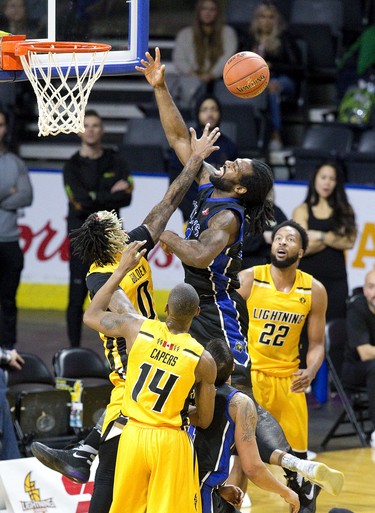 London Lightning  player Mo Bolden swats the ball away from Nigel Tyghter of the Kitchener-Waterloo Titans at Budweiser Gardens in London, Ont. on Sunday December 9, 2018.  Derek Ruttan/The London Free Press/Postmedia Network