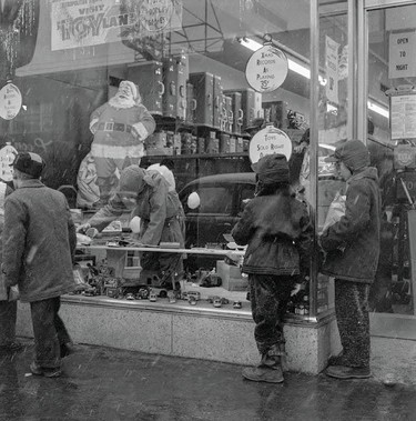 Young children window shopping during the Christmas season at the old Metropolitan Store in London East.