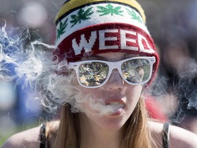 A woman exhales while smoking a joint during the annual 4/20 marijuana rally on Parliament hill on Wednesday, April 20, 2016, in Ottawa.