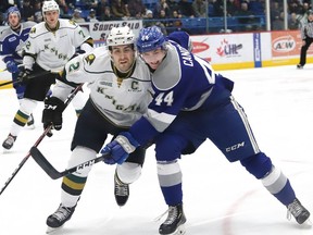 Evan Bouchard, left, of the London Knights, and Cole Candella, of the Sudbury Wolves, battle for the puck during OHL action at the Sudbury Community Arena in Sudbury, Ont. on Friday January 18, 2019. John Lappa/Sudbury Star/Postmedia Network