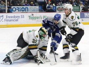 Quinton Byfield, middle, of the Sudbury Wolves, looks for a rebound as Joseph Raaymakers, of the London Knights, covers up the puck, while teammate Billy Moskal, looks on during OHL action at the Sudbury Community Arena in Sudbury, Ont. on Friday January 18, 2019. John Lappa/Sudbury Star/Postmedia Network