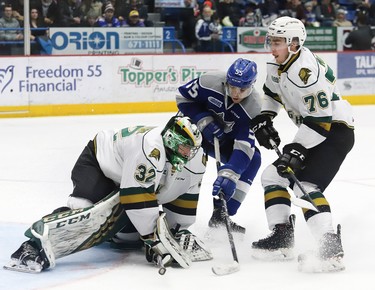 Quinton Byfield, middle, of the Sudbury Wolves, looks for a rebound as Joseph Raaymakers, of the London Knights, covers up the puck, while teammate Billy Moskal, looks on during OHL action at the Sudbury Community Arena in Sudbury, Ont. on Friday January 18, 2019. John Lappa/Sudbury Star/Postmedia Network