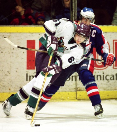 Back from the World Jr. Hockey Championships, Rick Nash of the London Knights powers around the Windsor net while being hooked by Spitfires Paul Glallonardo.  No penalty on the play and Nash was able to get a shot of the net, during first period action at the London Ice House, Jan.11/02.
(CP PHOTO DAVE CHIDLEY The London Free Press)