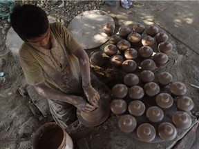 A Pakistani child potter makes earthen piggy banks at a workshop in Karachi on January 14, 2019.