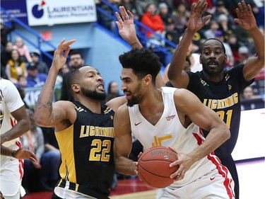 Cory Dixon, right, of the Sudbury Five, attempts to shoot over Marvell Waithe, of the London Lightning, during basketball action at the Sudbury Community Arena in Sudbury, Ont. on Friday January 4, 2019.  (John Lappa/Postmedia Network)