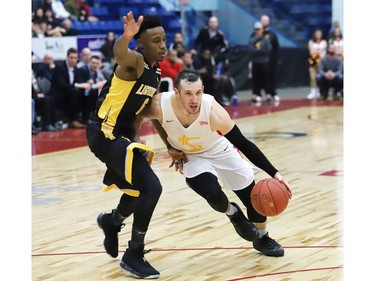 Adam Blazek, right, of the Sudbury Five, drives to the basket during basketball action against the London Lightning at the Sudbury Community Arena in Sudbury, Ont. on Friday January 4, 2019.  (John Lappa/Postmedia Network)