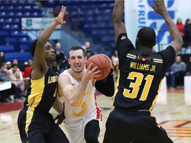 Adam Blazek, middle, of the Sudbury Five, drives to the basket during basketball action against the London Lightning at the Sudbury Community Arena in Sudbury, Ont. on Friday January 4, 2019.  (John Lappa/Postmedia Network)