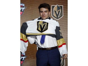 Nick Suzuki puts on a Vegas Golden Knights jersey after being selected by the team in the first round of the NHL hockey draft in Chicago on June 23, 2017.
