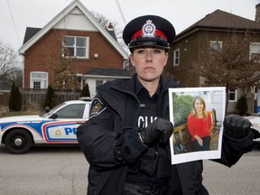 Police constable Sandasha Bough holds a photo of Shelley Desrochers at Lorne Ave. and English Street in London. Desrochers was last seen three years ago at this spot. Police are appealing for any information about her disappearance. (Derek Ruttan/The London Free Press)