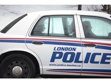 One of three suspects arrested after a home invasion sits in the back of a police car on Capulet Lane in London on Wednesday. (Derek Ruttan/The London Free Press)