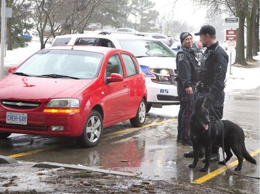 Police surround a car suspected of being used by a trio in a home invasion in London, Ont. on Wednesday. The car was parked at a Wonderland Road north apartment complex. Three suspects were arrested not far from the vehicle. (Derek Ruttan/The London Free Press)