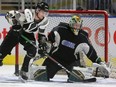 William Lochead, who took off his black jersey to play white, drives in front of Knights goaltender Joseph Raaymakers as the Knights practice their powerplay with Lochead, a defenceman using his size in front of the goalie on offence as a forward.  Photograph taken on Wednesday January 23, 2019.  (Mike Hensen/The London Free Press)