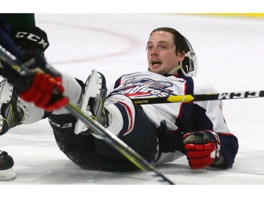 Ben Garagan of the Spits gets rocked by Cole Tymkin during their OHL game at Budweiser Gardens on Friday night. The Knights won 7-0.  (MIKE HENSEN, The London Free Press)