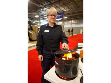 Tracy McLeish, a public educator for the London firedDepartment shows how to douse a grease fire simulation at the Lifestyle Homeshow at the Western Fair Agriplex  in London Friday. (Mike Hensen/The London Free Press)