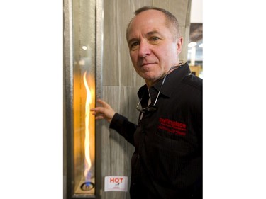 Todd Grigg shows off My Fireplace's vertical fire display at the Lifestyle Homeshow at the Western Fair Agriplex  in London on Friday. Grigg says people want new shape,s including wide low displays as well as this vertical style. (Mike Hensen/The London Free Press)