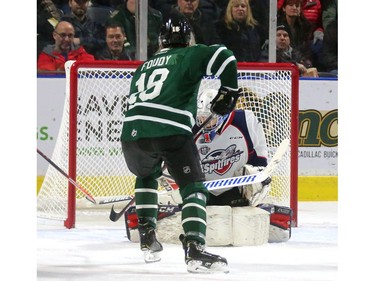 Liam Foudy of the Knights opens the scoring Friday night with a tip past Windsor's Kari Piiroinen during the first period of their OHL game at Budweiser Gardens. The Knights won 7-0.  (MIKE HENSEN, The London Free Press)