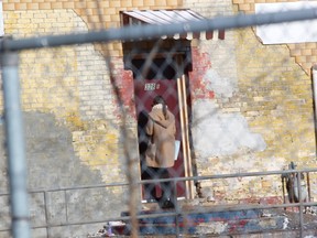 A woman waits to enter an illegal marijuana dispensary at 328 Hamilton Rd. in London on Thursday. Healing Health moved into the east-end building after vacating its previous two locations following a police crackdown on the black market businesses. DALE CARRUTHERS / THE LONDON FREE PRES