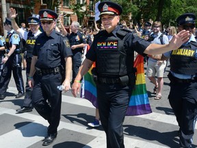 Former London Police Chief John Pare, centre, marchs with his officers during the annual Gay Pride Parade on Queen's Avenue in 2017. Because police uniforms, cruisers and guns can be triggering for many in the LGBTQ community, they are banned, again, from this year's parade. Police officers still will march in the parade in plain clothes.  (File photo)
