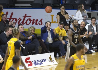 London Lightning team owner Vito Frijia tosses the ball back on the court after it went out of bounds and landed in his lap during the team's NBL game against the Moncton Magic  in London on Thursday. (Derek Ruttan/The London Free Press)