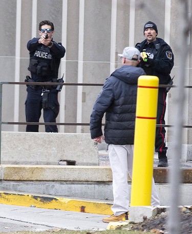 One police officer points his gun and another a points his Taser at a man who was armed with a large hunting knife on Wellington St. just north of Queens Ave in London, Ont. on Sunday January 6, 2019. After and hour-and-a-half of police were able to convince the man to to surrender. Derek Ruttan/The London Free Press/Postmedia Network