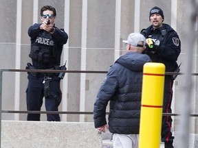 One London police officer points his gun and another points his Taser at a man who was armed with a large hunting knife on Wellington Street just north of Queens Avenue in London on Jan. 6, 2019. Police use of force was up in London in 2020 over 2019. (Derek Ruttan/The London Free Press)