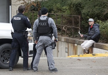 Although surrounded by by several police officers, a man held them at bay by holding a large hunting knife to his neck on Wellington St. just north of Queens Ave in London, Ont. on Sunday January 6, 2019. After and hour-and-a-half of police were able to convince the man to to surrender. Derek Ruttan/The London Free Press/Postmedia Network