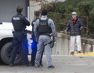 Although surrounded by by several police officers, a man held them at bay by holding a large hunting knife to his neck on Wellington St. just north of Queens Ave in London, Ont. on Sunday January 6, 2019. After and hour-and-a-half of police were able to convince the man to to surrender. Derek Ruttan/The London Free Press/Postmedia Network