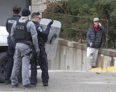 Although surrounded by by several police officers, a man held them at bay by holding a large hunting knife to his neck on Wellington St. just north of Queens Ave in London, Ont. on Sunday January 6, 2019. After and hour-and-a-half of police were able to convince the man to to surrender. Derek Ruttan/The London Free Press/Postmedia Network