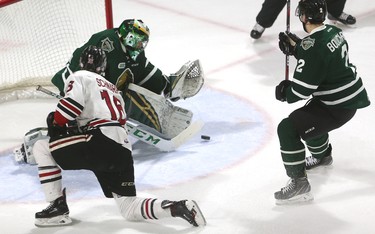 Joseph Raaymakers of the London Knights makes a save on Guelph Storm's Nate Schnarr with Evan Bouchard chasing during their Tuesday night game at Budweiser Gardens.  Mike Hensen/The London Free Press