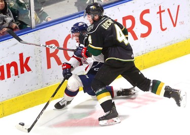 Knights William Lochead pins Saginaw's Damien Giroux into the end boards during the first period of their game Friday night at Budweiser Gardens in London, Ont.  Photograph taken on Friday January 11, 2019.  Mike Hensen/The London Free Press/Postmedia Network