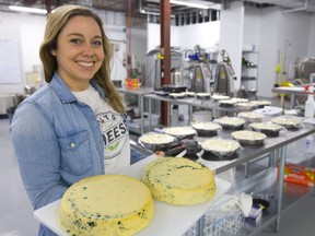 Margaret Coons founder of Nuts for Cheese is a vegan cheese maker located in London, Ont. holds up two of her blue cheese wheels at her facility. Coons says they are in over 600 stores across the country, and has been in operation for over three years.  Mike Hensen/The London Free Press/Postmedia Network