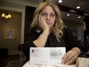 Dodie Wright with her London Hydro bill which is several times higher than normal due to a leaky toilet in London. Derek Ruttan/The London Free Press/Postmedia Network
