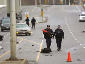 Traffic reconstruction officers start to put out pylons to mark the scene where a car and a motorized scooter crashed just east of Wonderland on Commissioners Road in London. The 63-year-old scooter driver died later in hospital, police said.. (Mike Hensen/The London Free Press)