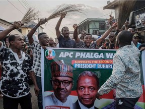 Supporters of Nigeria's incumbent President's party the All Progressives Congress (APC) march through local market in Port Harcourt, the opposition stronghold, southern Nigeria, on February 21, 2019. - Nigeria's presidential and parliamentary election has been rescheduled for February 23, 2019, following the postponement of the original poll on February 16.