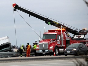 A crew from Chatham Towing works on removing a truck that crashed on the south side of Highway 401, west of the Drake Road overpass in Chatham-Kent Ont. on January 24, 2019 as a cameraman from the reality TV show Heavy Rescue: 401 films the action. (Ellwood Shreve/Chatham Daily News)