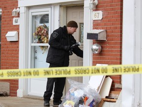 A London police forensic investigator photographs the scene at 67 Abour Glen Cres. on Feb. 5. Police were called to the address at 12:50 a.m. for a report of a man shot with an arrow. The man later died in the hospital. (DALE CARRUTHERS, The London Free Press)