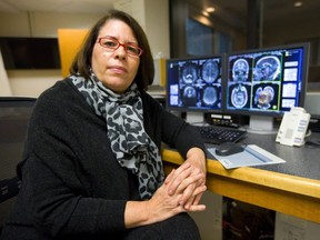 Dr. Ruth Lanius of the London Health Sciences Centre pauses by brain scans taken at Robarts Research Institute in London. Lanius uses brain scan technology to study post-traumatic stress disorder in patients. (Mike Hensen/London Free Press)